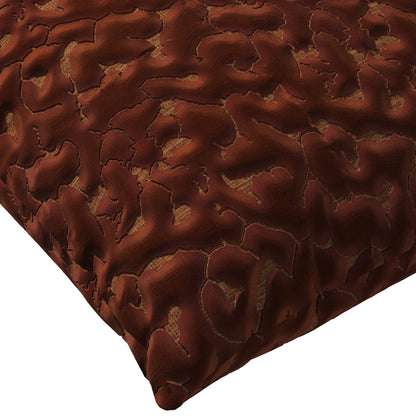 Copper colored throw pillow with an abstract texture.